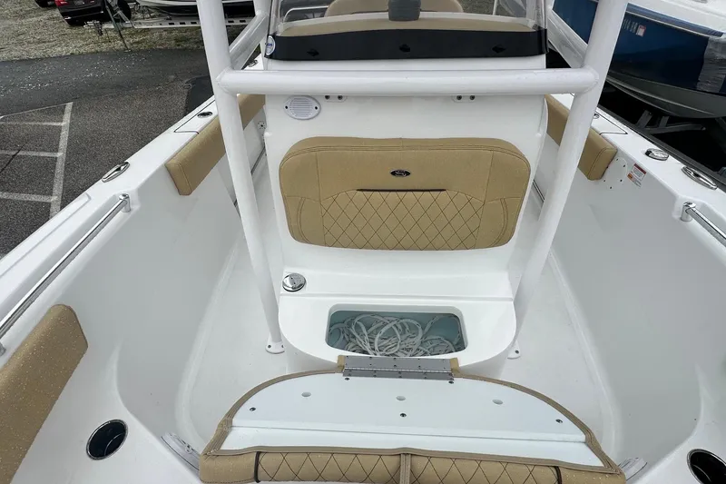 Slide: The Image of 2022 Sportsman Open 212 Center Console boat interior with tan seating and storage compartment. - 24