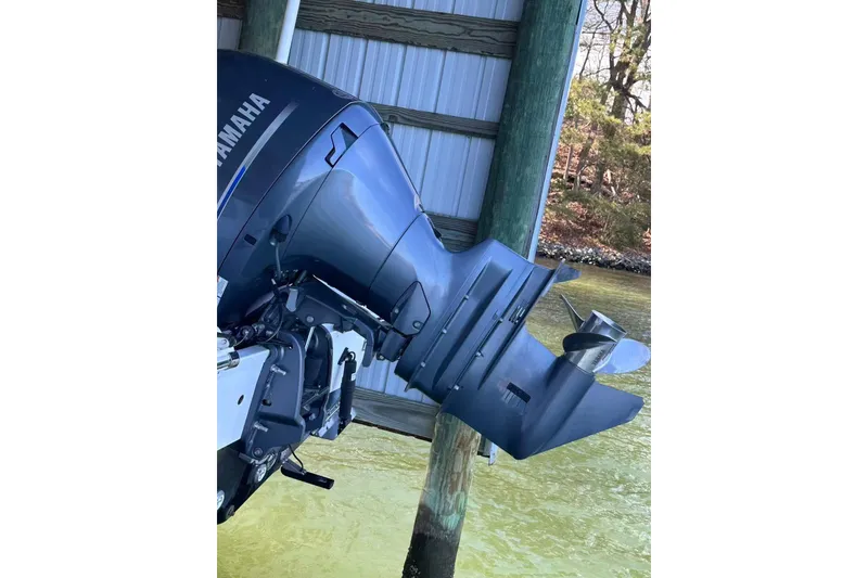 Slide: The Image of Outboard motor of 2022 Sportsman Open 212 Center Console boat, docked by water. - 3