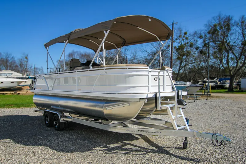 Slide: The Image of 2026 Veranda VR235L pontoon boat on trailer, parked outdoors under clear blue sky. - 5