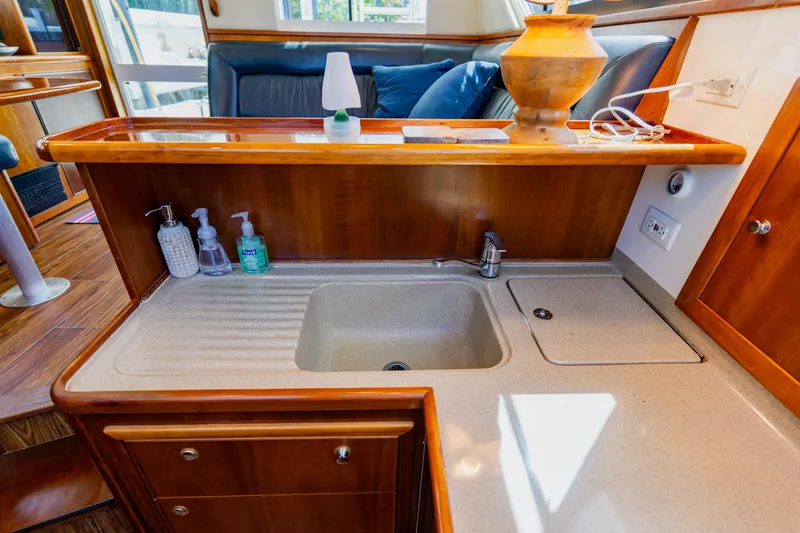 Slide: The Image of Luxurious 2003 Wellcraft 400 Coastal yacht interior with sink and wooden cabinetry. - 100