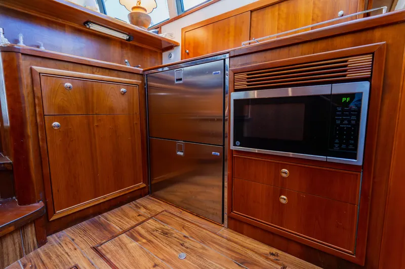 Slide: The Image of 2003 Wellcraft 400 Coastal yacht kitchen with wood cabinetry, stainless steel appliances, and microwave. - 103