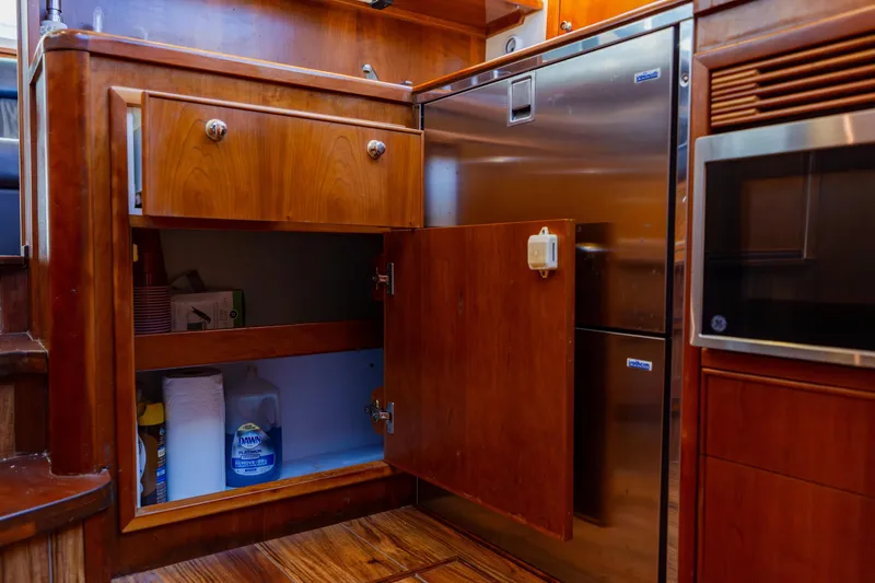Slide: The Image of 2003 Wellcraft 400 Coastal yacht kitchen with wooden cabinets and stainless steel appliances. - 105