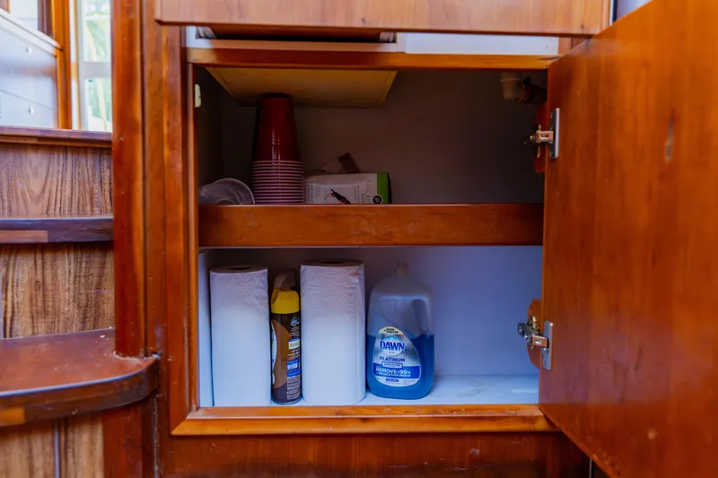 Slide: The Image of Cabinet storage on 2003 Wellcraft 400 Coastal boat with cleaning supplies and paper towels. - 106