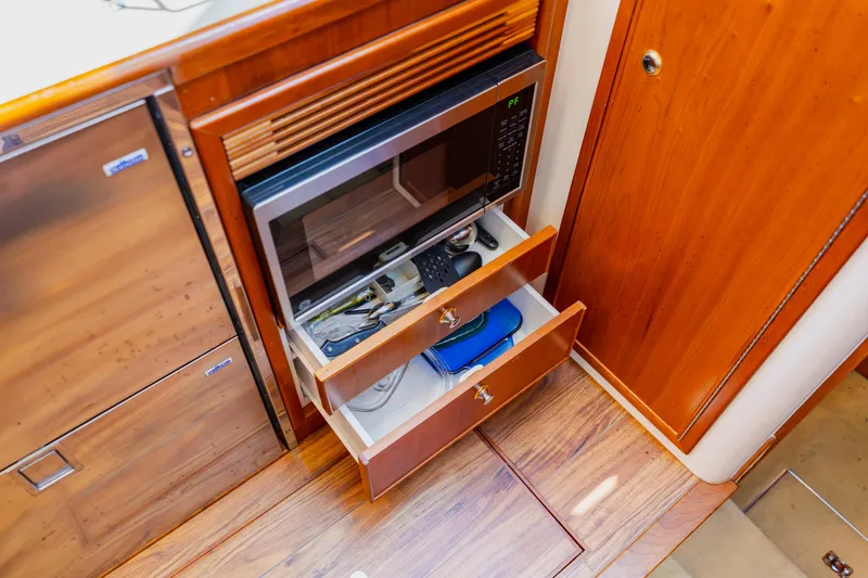 Slide: The Image of 2003 Wellcraft 400 Coastal interior with microwave and open wooden drawers. - 107