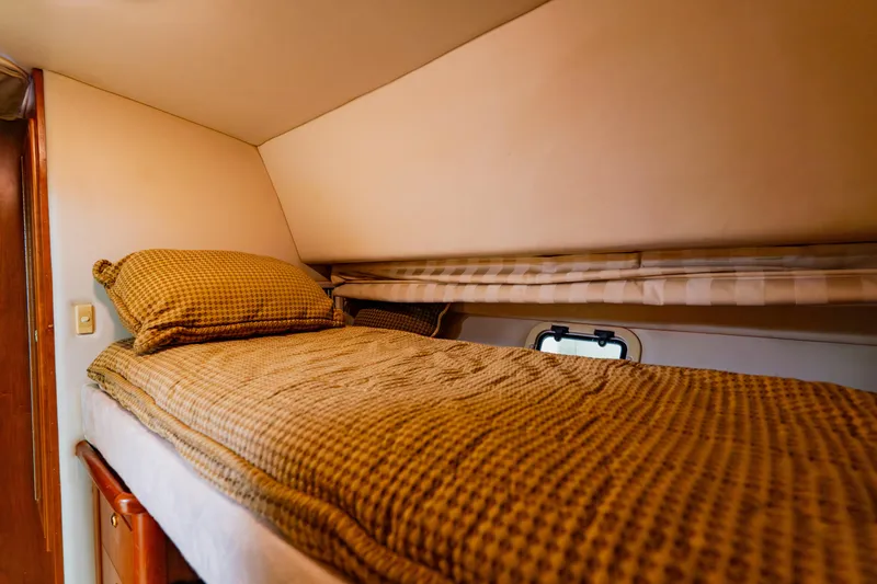 Slide: The Image of 2003 Wellcraft 400 Coastal cabin with cozy bedding and small window. - 119