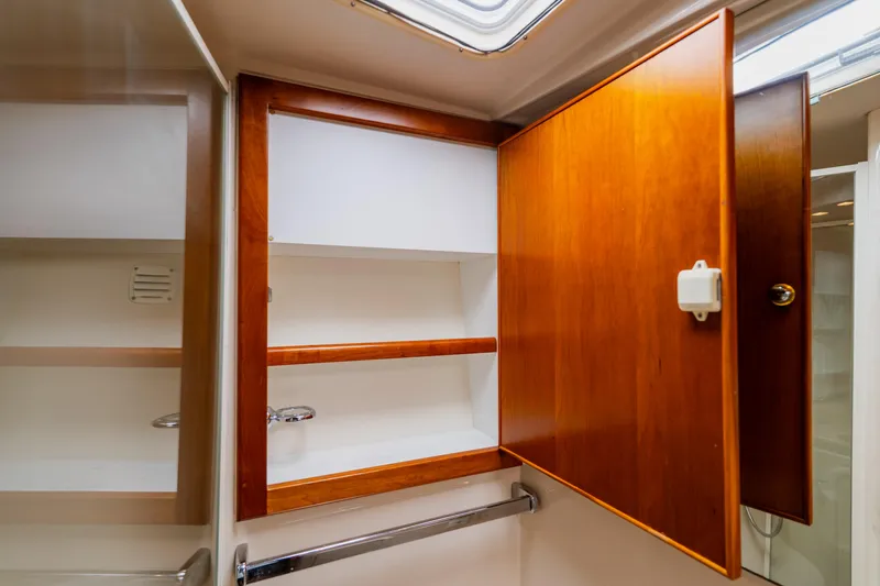 Slide: The Image of Wooden cabinet interior on 2003 Wellcraft 400 Coastal boat, showcasing storage space. - 128
