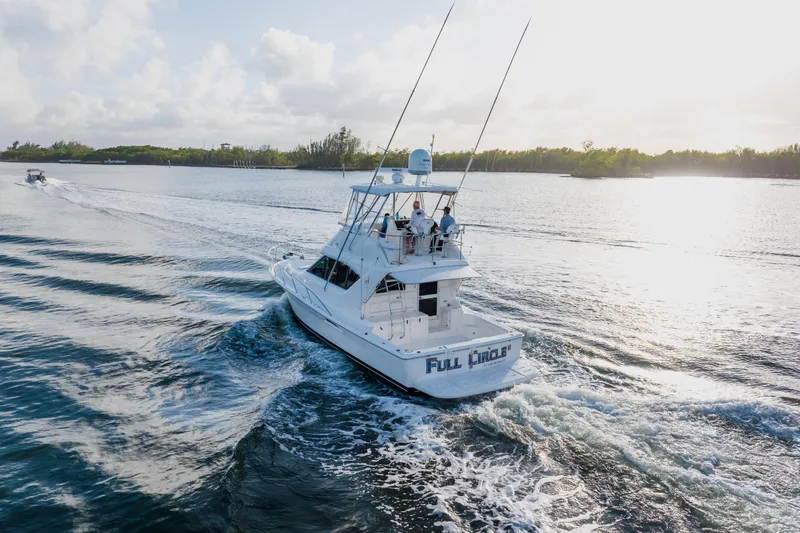 Slide: The Image of 2003 Wellcraft 400 Coastal yacht cruising on a sunny day, creating gentle waves. - 129