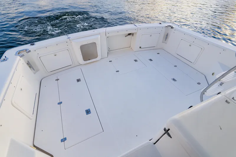 Slide: The Image of Spacious deck of 2003 Wellcraft 400 Coastal boat, featuring storage compartments and water view. - 13