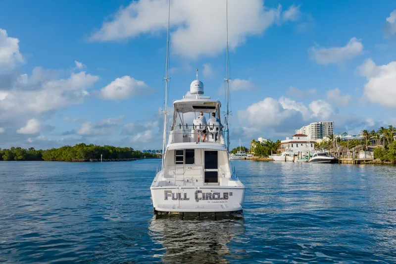 Slide: The Image of 2003 Wellcraft 400 Coastal boat on water, clear sky, waterfront buildings in background. - 2