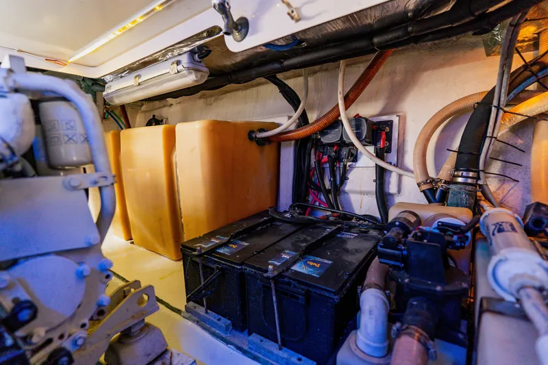Slide: The Image of Engine room of a 2003 Wellcraft 400 Coastal boat, featuring batteries and fuel tanks. - 39