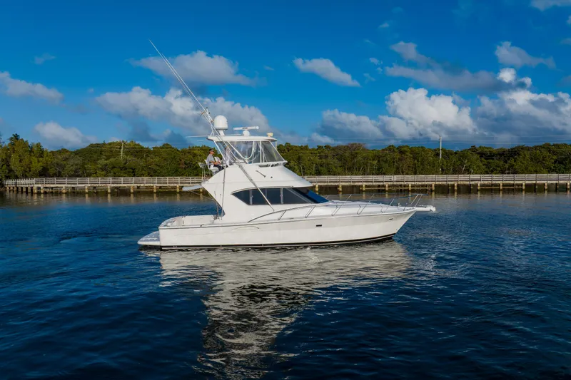 Slide: The Image of 2003 Wellcraft 400 Coastal yacht cruising on a serene waterway under a clear blue sky. - 4