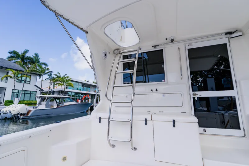 Slide: The Image of 2003 Wellcraft 400 Coastal yacht docked, featuring a sleek ladder and modern design elements. - 44