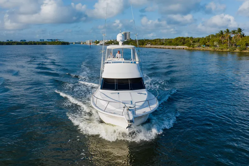 Slide: The Image of 2003 Wellcraft 400 Coastal yacht cruising on a scenic waterway under a blue sky. - 6