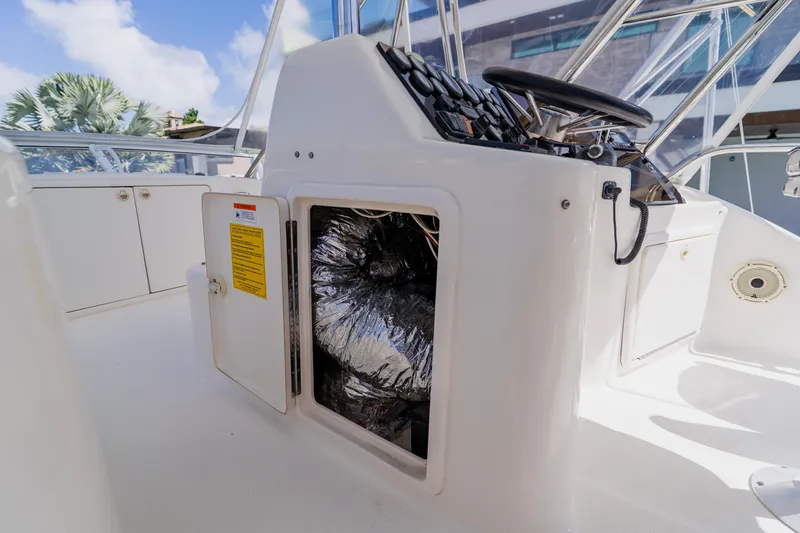 Slide: The Image of 2003 Wellcraft 400 Coastal boat helm with open storage compartment, showcasing interior details. - 63