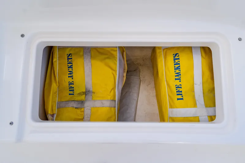 Slide: The Image of Yellow life jackets stored in a compartment on a 2003 Wellcraft 400 Coastal boat. - 64