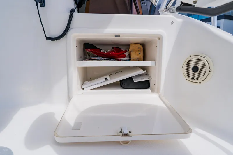 Slide: The Image of Open storage compartment on 2003 Wellcraft 400 Coastal boat, containing various items and a speaker. - 65
