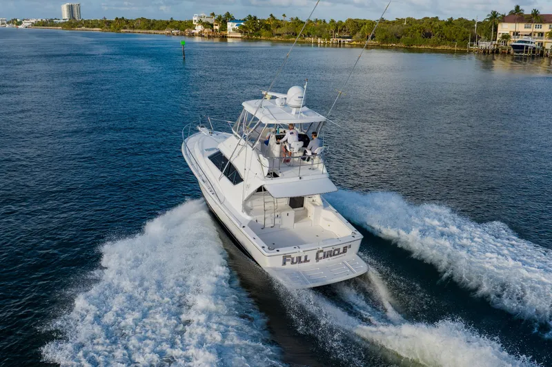 Slide: The Image of 2003 Wellcraft 400 Coastal yacht cruising on a scenic waterway, creating a wake behind. - 7