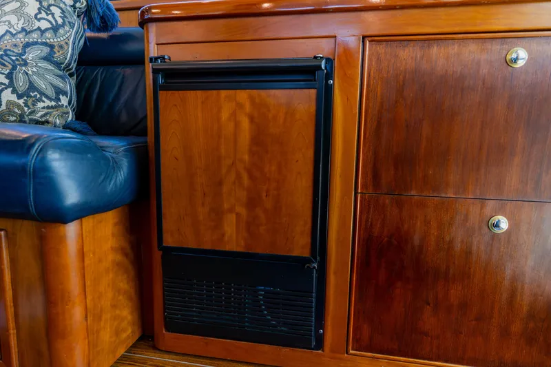 Slide: The Image of Wooden interior of 2003 Wellcraft 400 Coastal yacht with built-in fridge and blue leather seating. - 90