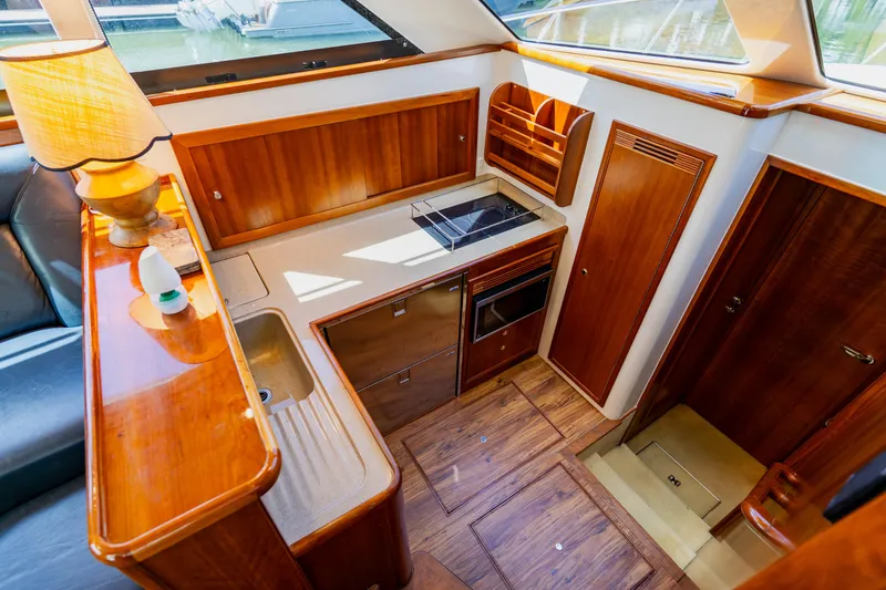 Slide: The Image of Luxurious 2003 Wellcraft 400 Coastal yacht interior with wooden cabinetry and modern kitchen amenities. - 98