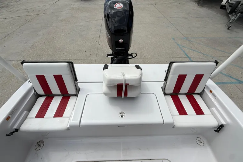 Slide: The Image of 2005 Champion 22 Bay Champ boat interior with red and white seating and motor. - 13