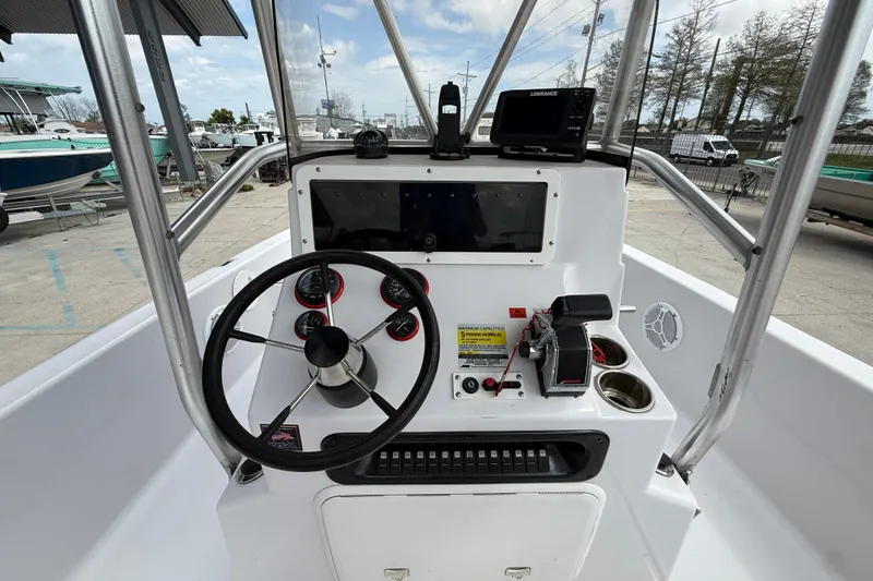 Slide: The Image of Center console of a 2005 Champion 22 Bay Champ boat with steering wheel and controls. - 14