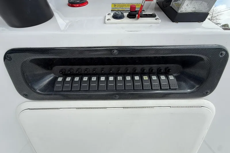 Slide: The Image of Control panel of a 2005 Champion 22 Bay Champ boat with multiple switches. - 15