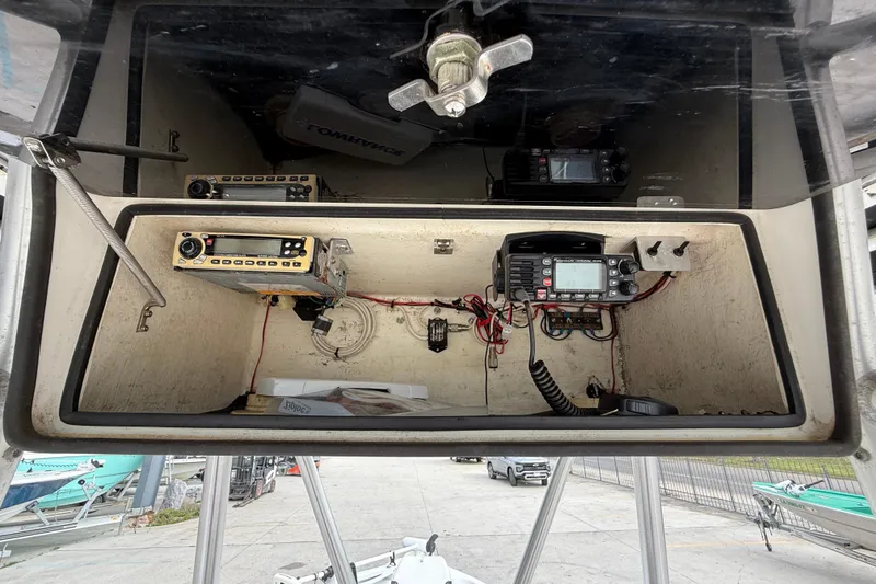 Slide: The Image of 2005 Champion 22 Bay Champ boat electronics compartment with radio and wiring. - 16