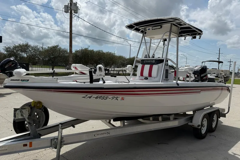 Slide: The Image of 2005 Champion 22 Bay Champ boat on trailer, parked outdoors under cloudy sky. - 3