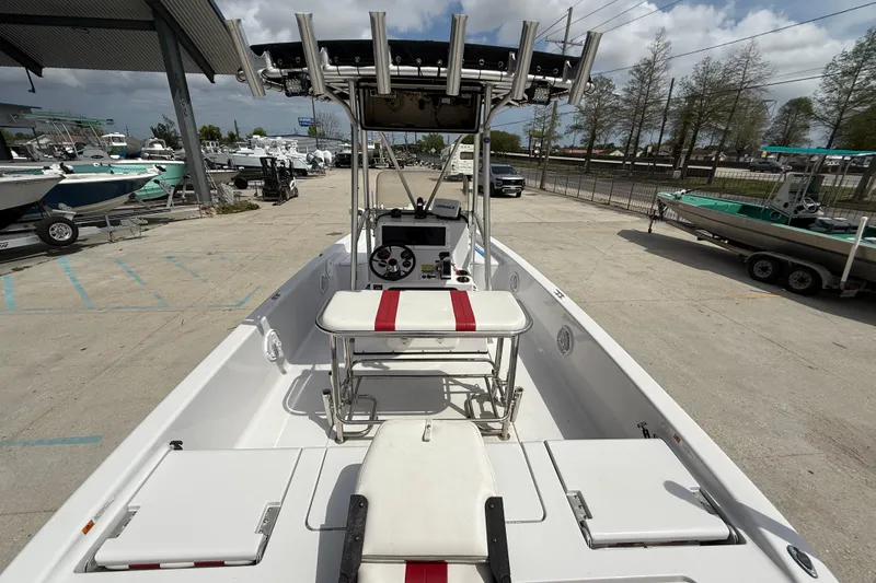 Slide: The Image of 2005 Champion 22 Bay Champ boat with T-top and seating, parked at a marina. - 7