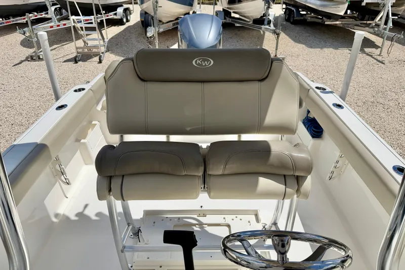 Slide: The Image of 2024 Key West 239 FS boat interior with cushioned seating and steering wheel. - 17