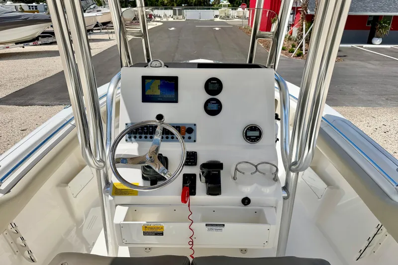 Slide: The Image of 2024 Key West 239 FS boat dashboard with steering wheel, navigation screen, and controls. - 18