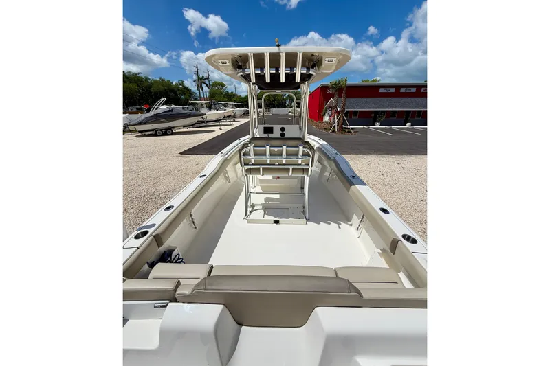 Slide: The Image of 2024 Key West 239 FS boat interior with seating and console, under a clear blue sky. - 22
