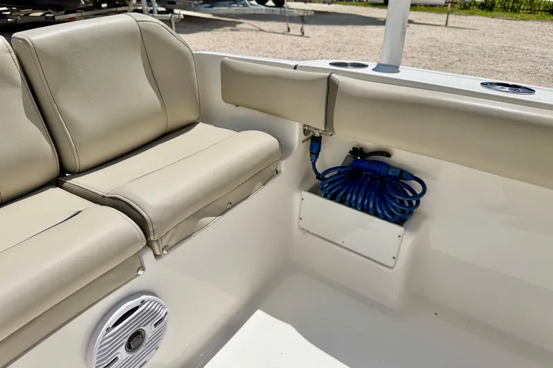 Slide: The Image of 2024 Key West 239 FS boat interior with beige seating and coiled blue hose. - 24