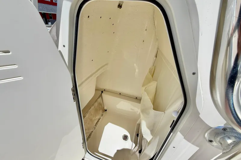 Slide: The Image of 2024 Key West 239 FS boat interior storage compartment with open door. - 28