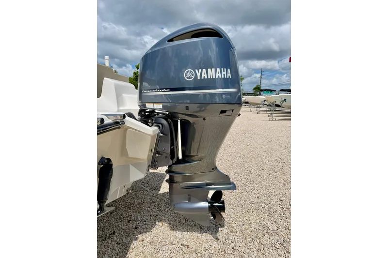 Slide: The Image of 2024 Key West 239 FS boat with Yamaha four-stroke outboard motor, parked on gravel. - 34