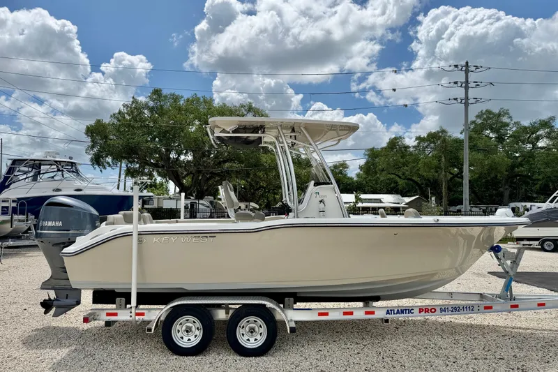 Slide: The Image of 2024 Key West 239 FS boat on trailer, parked outdoors under a cloudy sky. - 4