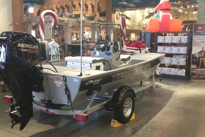 Slide: The Image of 2026 Tracker Bass Tracker Classic CC boat displayed indoors with Mercury engine. - 3