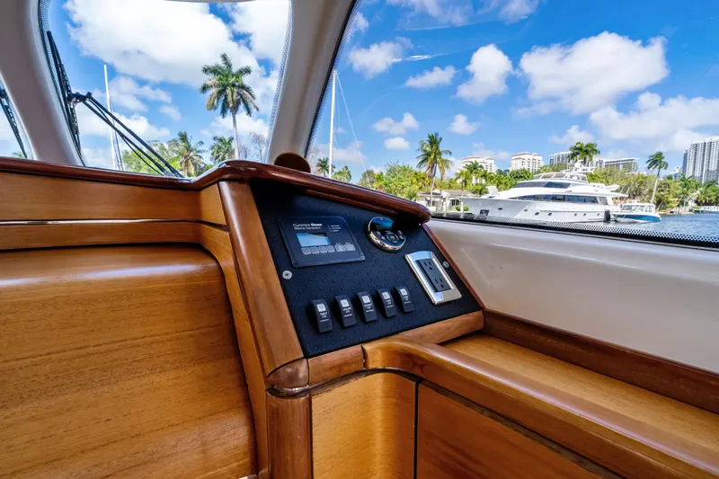 Slide: The Image of Interior view of 2012 Zeelander 44 yacht with wooden dashboard and scenic marina backdrop. - 13