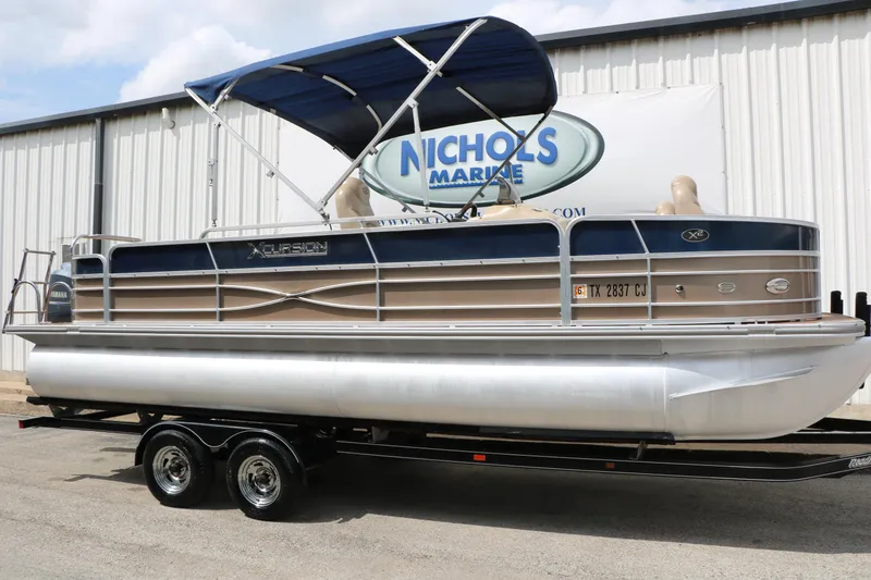 The Image of 2014 Xcursion X23F pontoon boat with blue canopy on trailer at Nichols Marine. - 1