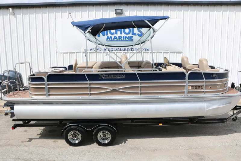 Slide: The Image of 2014 Xcursion X23F pontoon boat with blue canopy on trailer at Nichols Marine. - 10