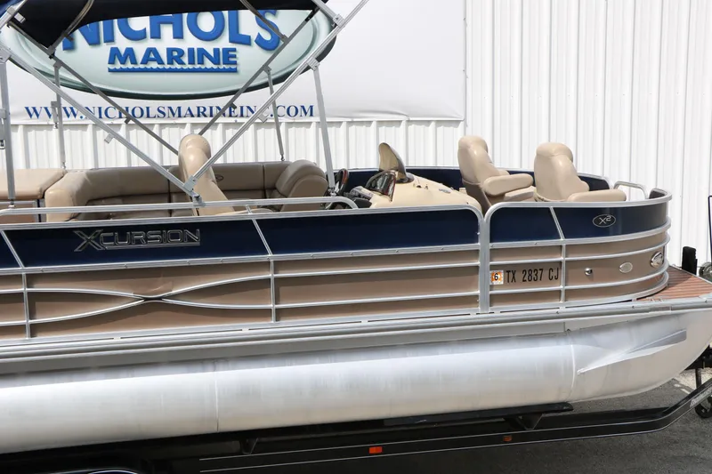 Slide: The Image of 2014 Xcursion X23F pontoon boat with beige seating and blue accents at Nichols Marine. - 11
