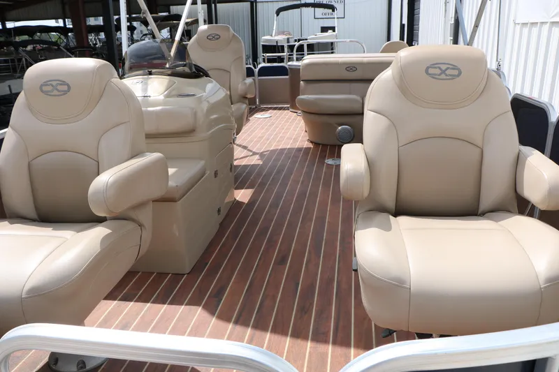 Slide: The Image of 2014 Xcursion X23F boat interior with beige seating and wood-style flooring. - 17
