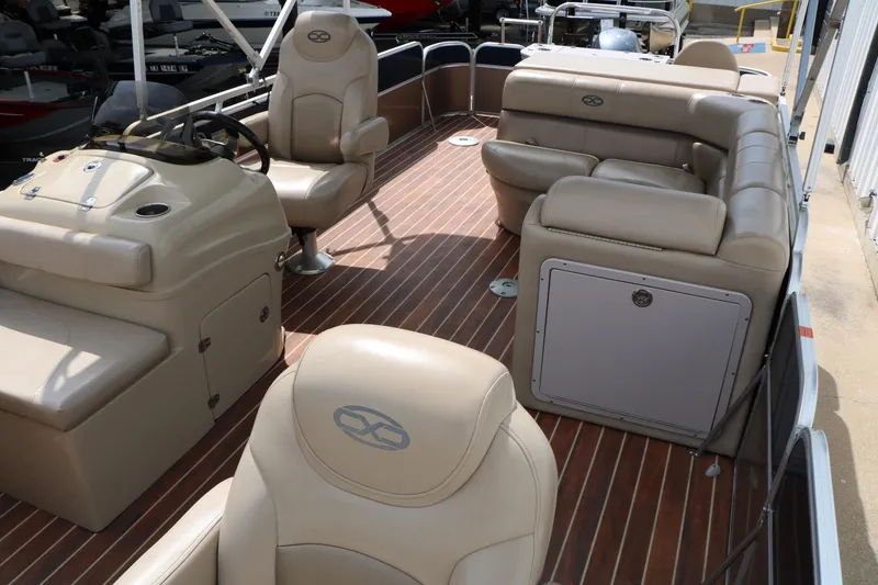 Slide: The Image of 2014 Xcursion X23F pontoon boat interior with beige seating and wood-style flooring. - 18