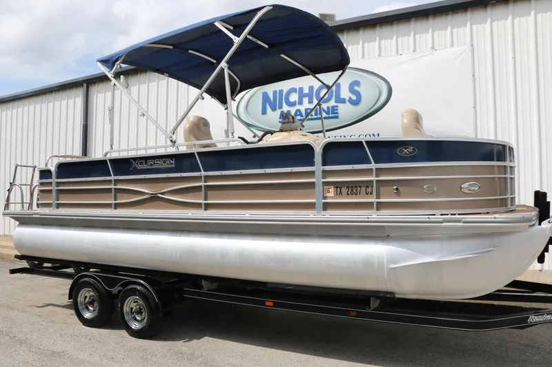 Slide: The Image of 2014 Xcursion X23F pontoon boat with canopy on trailer at Nichols Marine. - 2