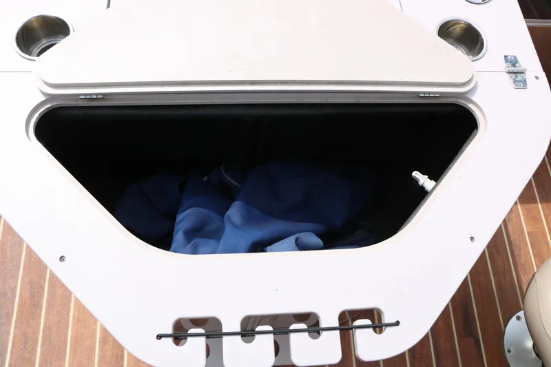 Slide: The Image of Storage compartment on 2014 Xcursion X23F boat with blue fabric inside. - 23