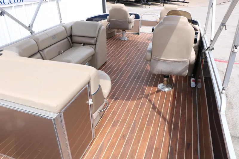 Slide: The Image of 2014 Xcursion X23F pontoon boat interior with beige seating and wood-style flooring. - 27