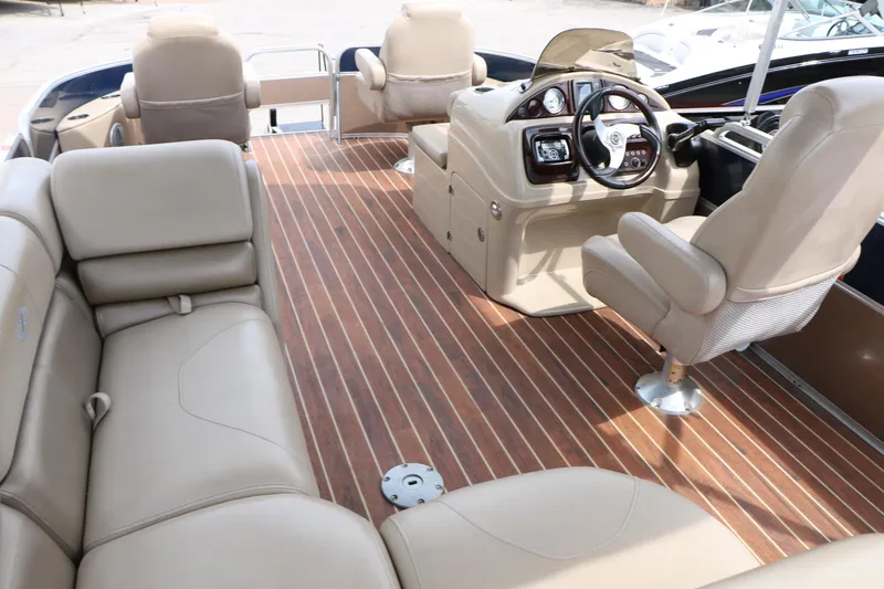 Slide: The Image of 2014 Xcursion X23F boat interior with beige seating and wood-style flooring. - 29
