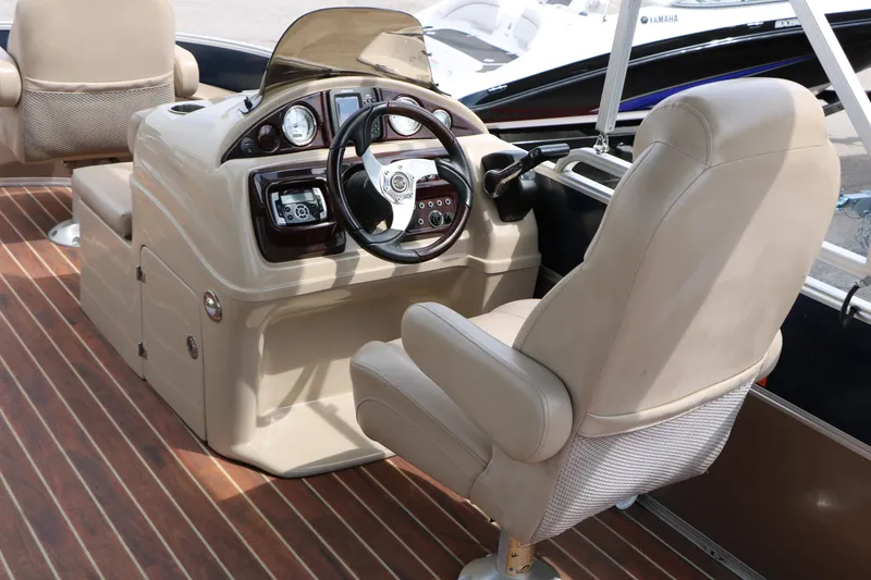 Slide: The Image of 2014 Xcursion X23F boat interior with steering console and beige captain's chair. - 30