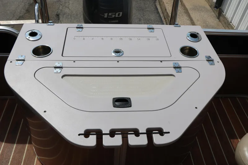Slide: The Image of 2014 Xcursion X23F boat console with cup holders and storage compartments. - 37
