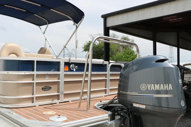 Slide: The Image of 2014 Xcursion X23F pontoon boat with Yamaha outboard motor, docked under a shelter. - 8